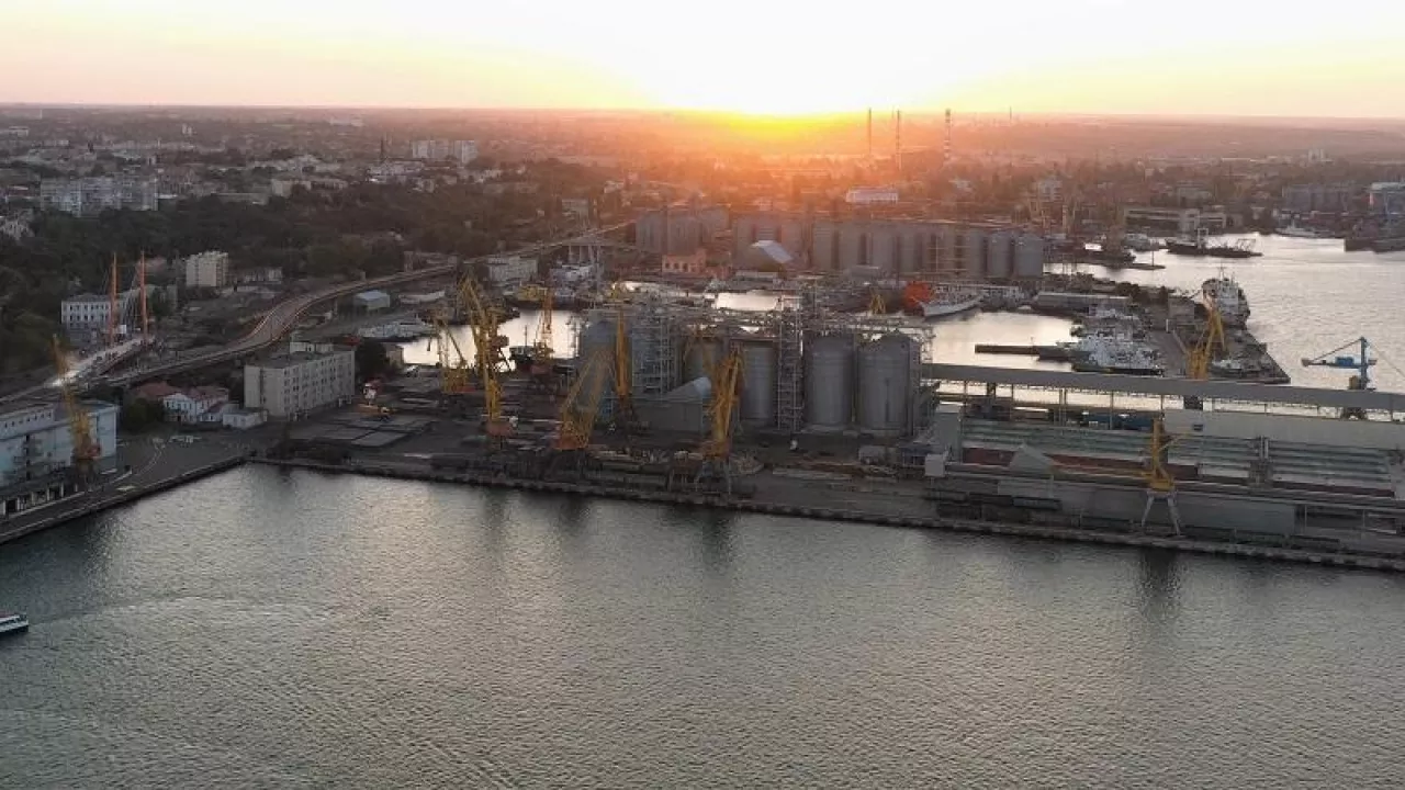 Sea port with tower cranes and grain terminals. Evening sunset light.