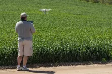 Pilot Flying Unmanned Aircraft Drone Gathering Data Over Country Farmland Field.