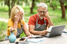 Financial Crisis. Upset Mature Farmers Couple Checking Bills With Laptop At Garden Terrace, Depressed Senior Spouses Small Business Owners Controlling Monthly Income, Suffering Economy Problems