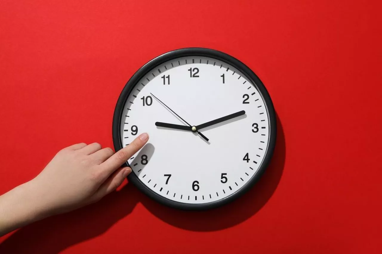 Concept of time change with clock on red background
