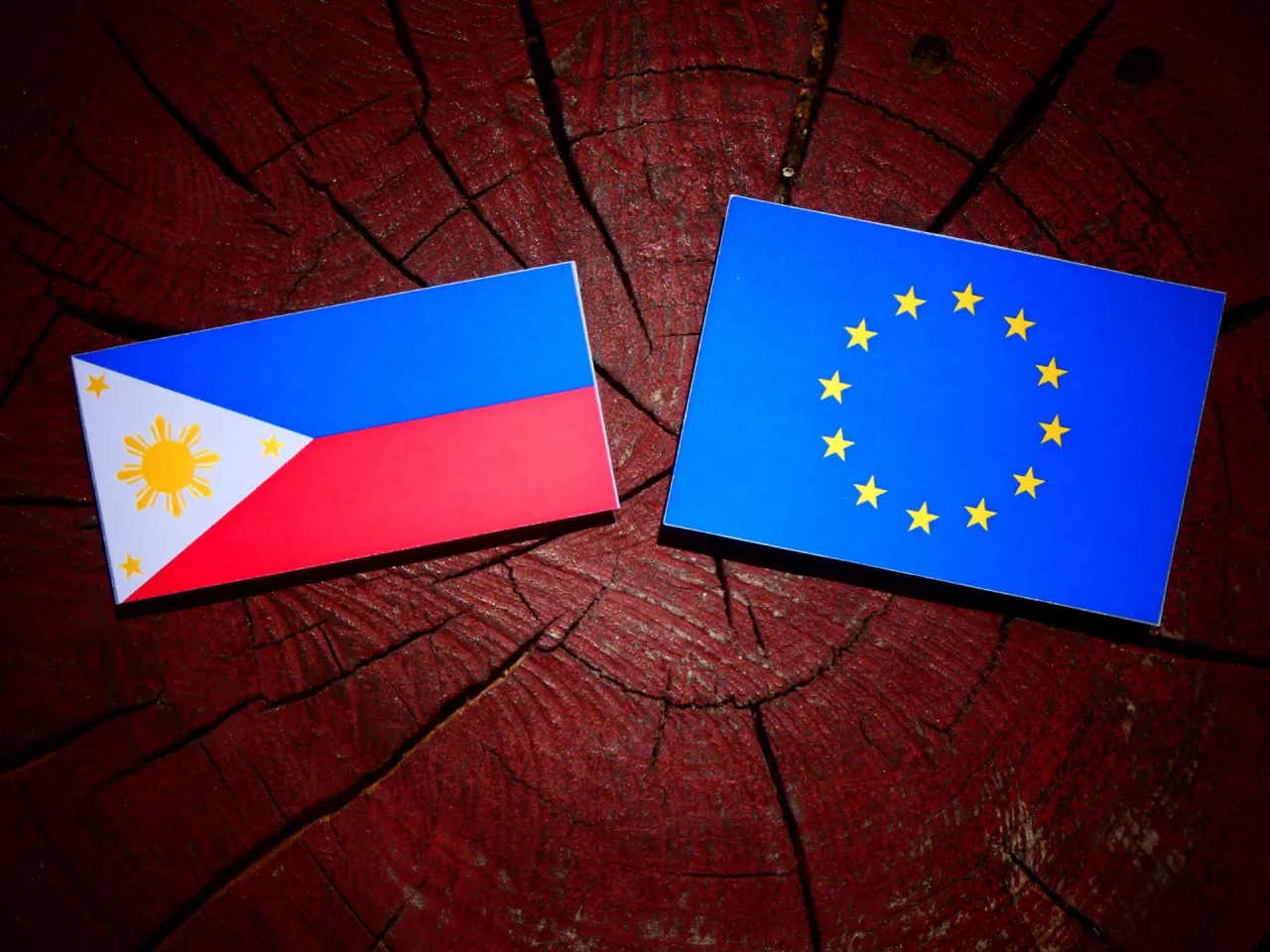 Philippines flag with EU flag on a tree stump isolated