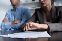 partial view of couple at table with divorce documents