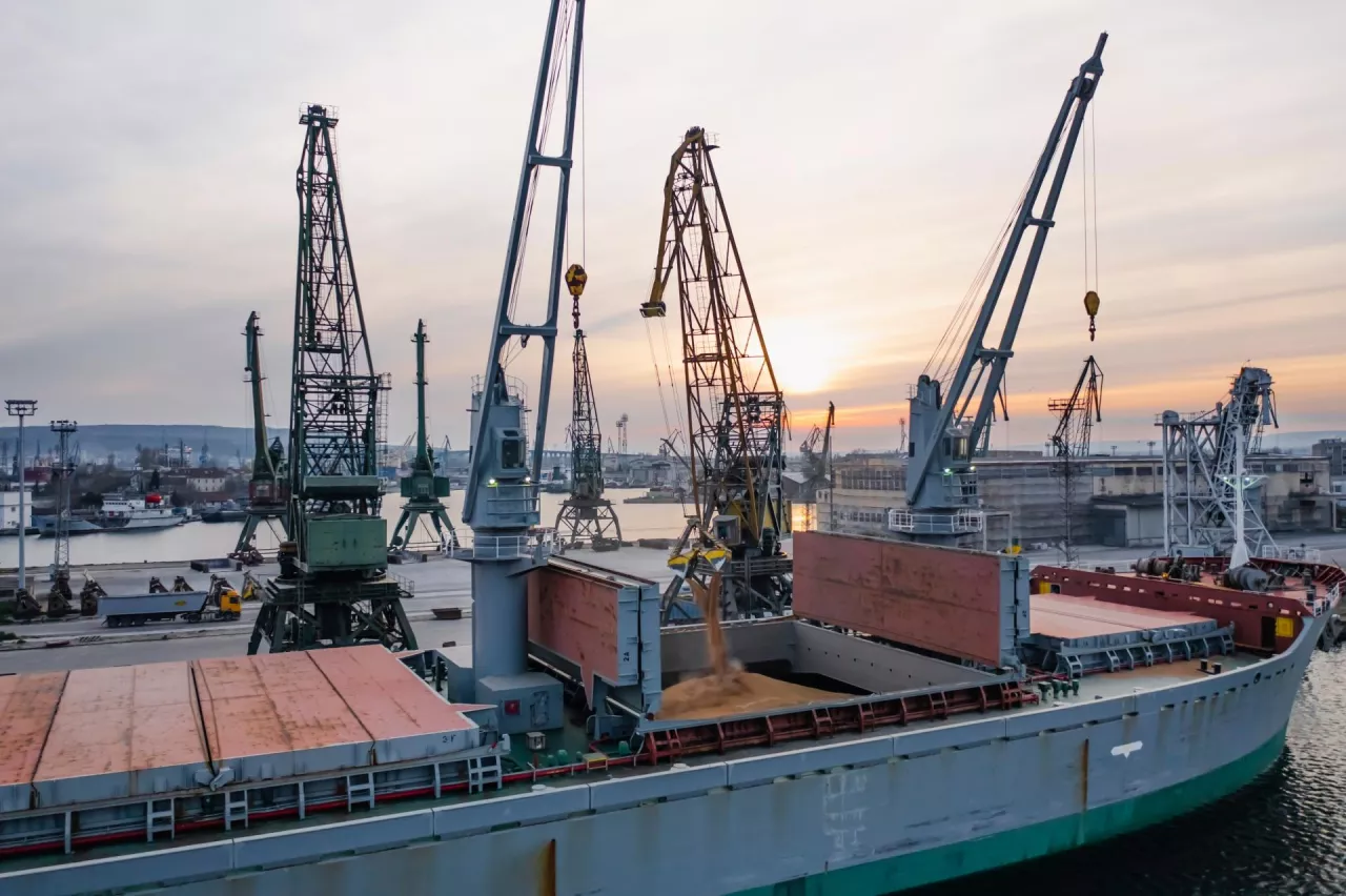 Black Sea Grain Initiative 2023 grain Deal. Silhouettes of port cranes during the loading of grain on a bulk carrier at sunset during the golden hour. Panoramic flight from a drone