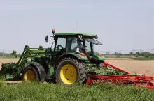 ciągnik John Deere z kultywatorem na polu