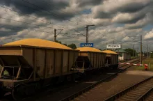 Fotorealistyczna wizualizacja eksportu zboża z Ukrainy. Pociąg towarowy z wagonami wypełnionymi ziarnem przekracza granicę z Polską. W tle widoczne elementy infrastruktury kolejowej i budynki odprawy celnej