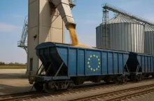 Fotorealistyczna scena załadunku ukraińskiego zboża do wagonów towarowych na szerokotorowym torze. Widoczna infrastruktura terminalu: silosy, taśmociąg zsypowy i wagon z symbolem UE.
