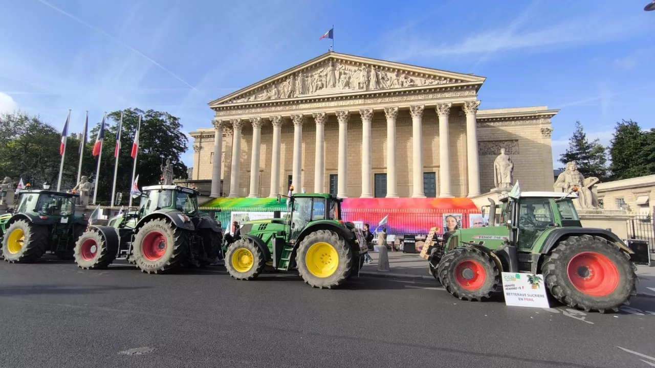 Ciągniki rolnicze ustawione przed Zgromadzeniem Narodowym w Paryżu podczas protestu organizowanego przez federację FNSEA i organizację CGB. Francuscy rolnicy wyrażają sprzeciw wobec planowanej umowy handlowej UE–Mercosur, wskazując na zagrożenia dla sektora buraka cukrowego. Na transparentach widnieje hasło ”Betterave sucrière en péril” – ”Burak cukrowy w niebezpieczeństwie”.