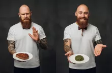 Kontrastowa grafika ukazująca brodatego mężczyznę w muszce, który z wyraźnym grymasem odsuwa od siebie talerz ze stekiem, a w drugiej scenie uśmiecha się, prezentując roślinny zamiennik. Symboliczna ilustracja polityki promowanej przez Danię podczas jej prezydencji w UE – zamiast walki o budżet WPR, nacisk na przejście na dietę roślinną.