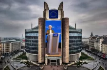 Fotomontaż przedstawiający budynek Komisji Europejskiej w Brukseli (Berlaymont) z banerem Ursuli von der Leyen przemawiającej podczas szczytu UE–Kanada. Realistyczna kompozycja z flagą Unii Europejskiej na szczycie budynku.
