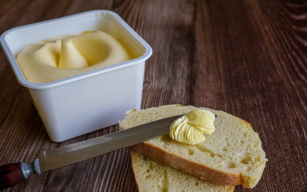 A slice of bread spread with creamy butter.