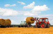 Ciągnik z belą słomy podczas żniw w Europie Środkowo-Wschodniej