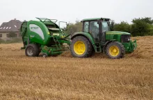 ciągnik z prasą zwijającą na polu