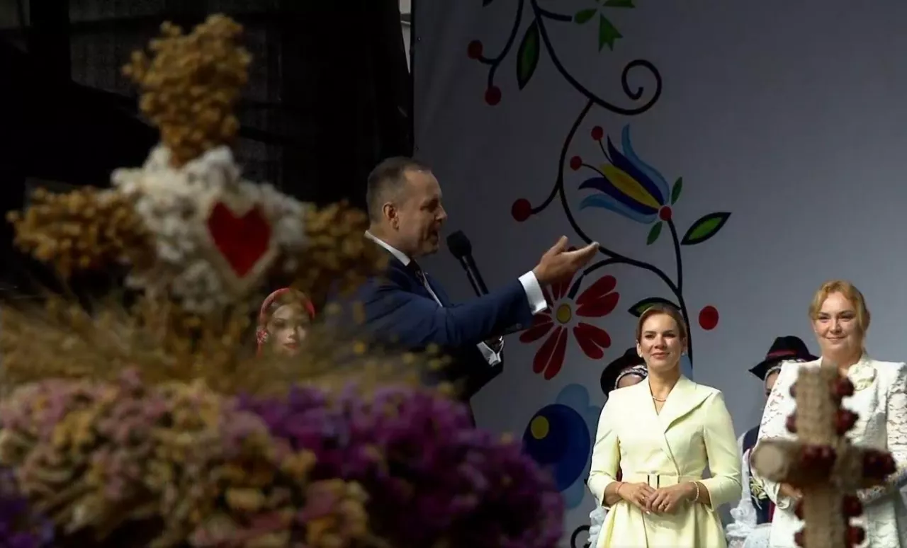 Dożynki Prezydenckie 2025. Prezydent Karol Nawrocki i Pierwsza Dama Marta Nawrocka oraz starościna Dożynek Jolanta Ciochoń. Na pierwszym planie zwycięski wieniec dożynkowy