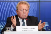 Komisarz UE ds. rolnictwa Janusz Wojciechowski przemawia podczas konferencji prasowej w siedzibie Komisji Europejskiej w Brukseli. Na zdjęciu widoczny stół z tabliczką imienną oraz mikrofon. W tle logo instytucji unijnych.