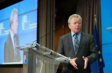 Były komisarz UE ds. rolnictwa Janusz Wojciechowski podczas konferencji prasowej w siedzibie Rady Unii Europejskiej w Brukseli. W tle logo Rady UE i flaga unijna.
