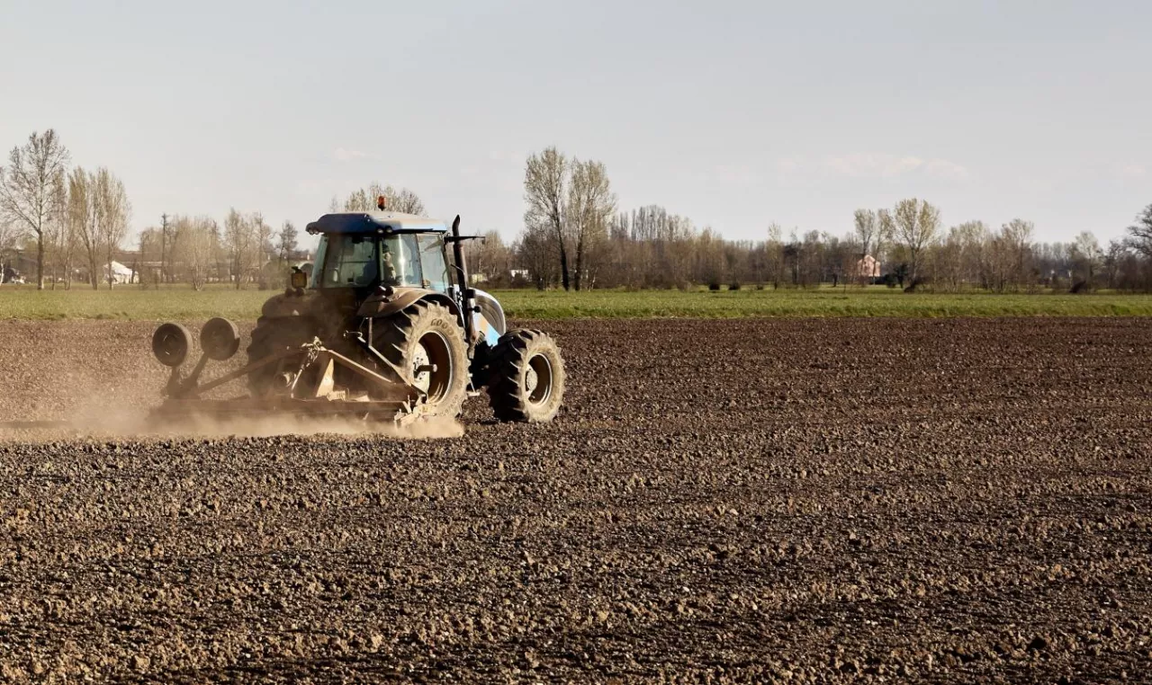 Ciągnik z agregatem uprawowym podczas uprawy przedsiewnej.