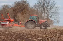 Rolnik pracujący nowoczesnym ciągnikiem z siewnikiem precyzyjnym podczas wiosennego siewu. Zdjęcie ilustruje tematykę innowacji i technologii w rolnictwie, poruszaną podczas konferencji UE–Ameryka Północna 2025.