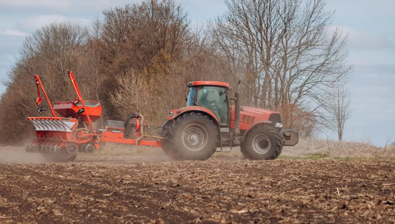Rolnik pracujący nowoczesnym ciągnikiem z siewnikiem precyzyjnym podczas wiosennego siewu. Zdjęcie ilustruje tematykę innowacji i technologii w rolnictwie, poruszaną podczas konferencji UE–Ameryka Północna 2025.