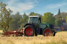 Ciągnik rolniczy marki Fendt podczas pracy na polu, na tle wiejskiego krajobrazu z zabudowaniami i drzewami.