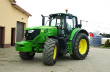 Ciągnik John Deere&#039;a 6155M na placu gospodarstwa rolnego