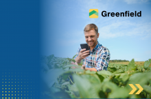 rolnik z telefonem komórkowym w polu, w tle logo aplikacji greenfield