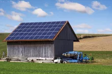 Green energy with solar collectors on the roof of an agricultural building