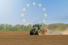 Ciągnik rolniczy z kultywatorem z symbolami UE