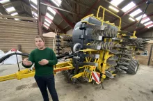 Rolnik Frank Keinicke Nielsen, stojący w hali koło agregatu uprawowego