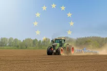 Ciagnik rolniczy z kultywatorem z symbolami UE