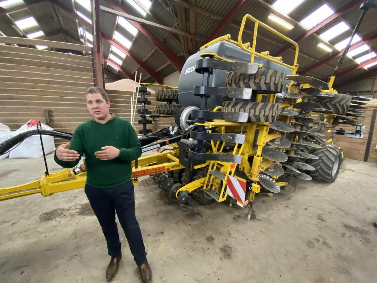 Rolnik Frank Keinicke Nielsen, stojący w hali koło agregatu uprawowego