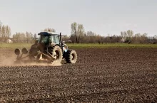 Ciągnik z agregatem uprawowym podczas uprawy przedsiewnej.