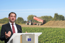 Komisarz UE ds. rolnictwa Chrostophe Hansen przemawiający na tle pola buraków cukrowych i zbioru buraków.