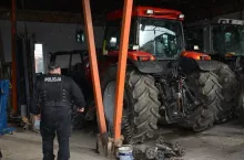 Policjant kontrolujący wiatę ciągnikową w gospodarstwei rolnym