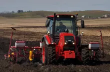 Ciągnik Belarus z agregatem uprawowym w polu