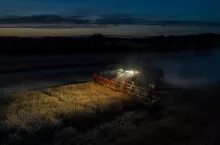 Kombajn zbożowy zbierający zboże w nocy