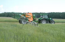 Ciągnik z opryskiwaczem na polu