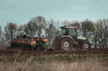 stary ciągnik rolniczy ciągnie przyczepę