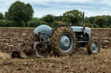 Ciągnik Ferguson TE20 z pługiem na polu. Zdjęcie ilustracyjne do tematu przyszłości dopłat bezpośrednich po 2032 r., w tym propozycji wyłączenia rolników-emerytów ze wsparcia dochodowego w ramach nowej WPR.