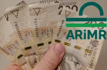 dłoń trzymająca banknoty, logo ARiMR po prawej