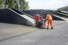 Po ułożeniu asfaltu wycina się szczelinę między rynną a asfaltem, a następnie wypełnia się ją gorącą masą.