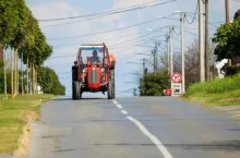 ciągnik rolniczy poruszający się drogą gminną