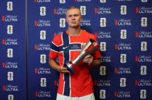 Erling Braut Haaland przy ściance trzyma w rękach nagrodę 