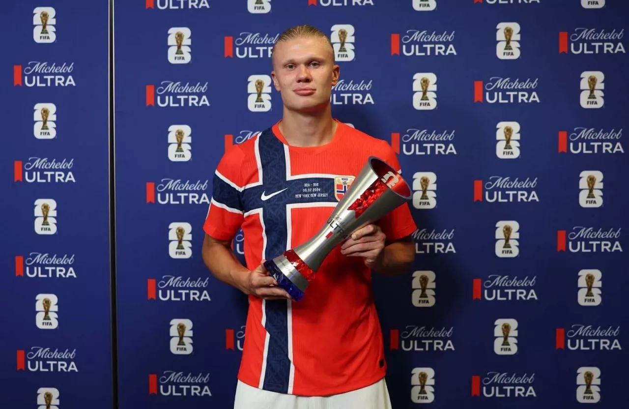 Erling Braut Haaland przy ściance trzyma w rękach nagrodę 
