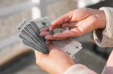 dłonie z baknotami polskimi i monetami