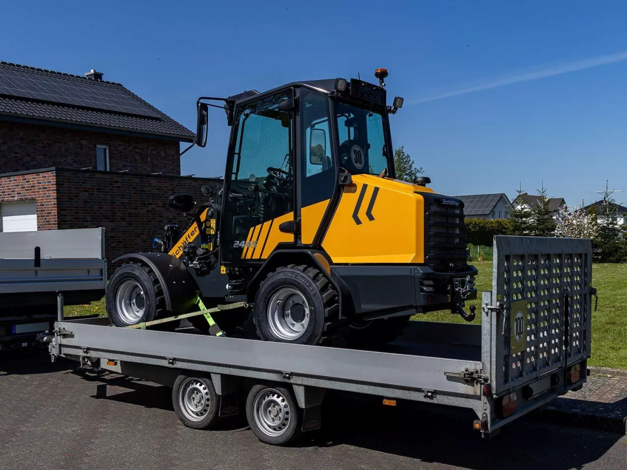 Ładowarka Schäffer 2445-2 transportowany za pomocą naczepy niskopodwoziowej
