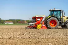 Siewnik Pöttinger Aerosem zaczepiony do ciągnika podczas prac polowych