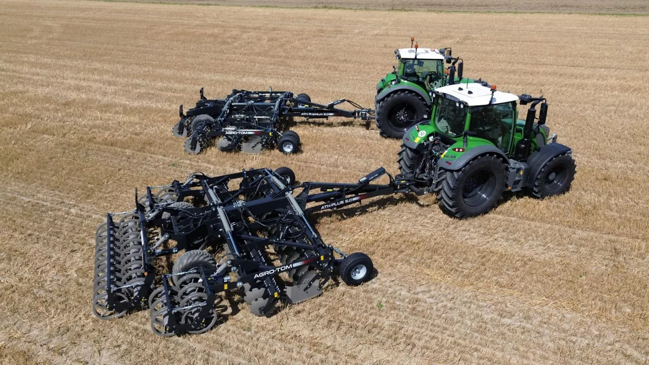 Dwa ciągniki z bronami talerzowymi Agro-Tom na ściernisku.