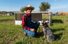 Łukasz Marciniak wraz ze swoim psem Chilli rasy Australian Cattle Dog na pastwisku przy moblinym kurniku
