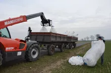 Rozładowywanie big bagów z nawozami z przyczepy za pomocą ładowarki teleskopowej
