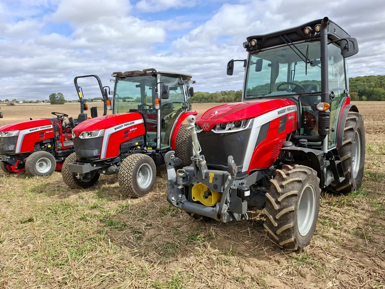 3 kompaktowe ciągniki Massey Ferguson stoją obok siebie na polu